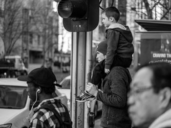Rear view of friends standing on street in city