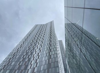 Low angle view of modern glass building against sky