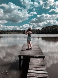 Woman standing on pier over lake