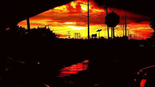 Silhouette of street light against sky at night