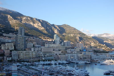 Cityscape by sea against clear sky