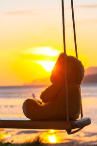 Close-up of rope on beach against sky during sunset