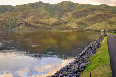 Scenic view of lake by mountains against sky