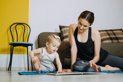 Learning activities for toddlers baby. mother reading book with cute toddler baby daughter