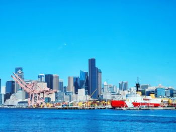 Boats in sea against clear blue sky