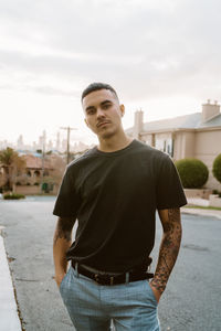 Portrait of young man standing in city