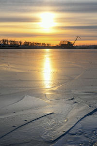 Scenic view of frozen sea against sky during sunset