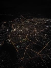 Aerial view of illuminated cityscape against sky at night