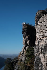 Low angle view of rock formations against clear blue sky