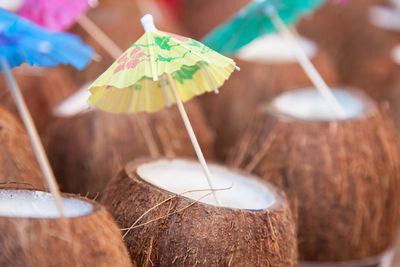 Close-up of coconuts with drink umbrellas