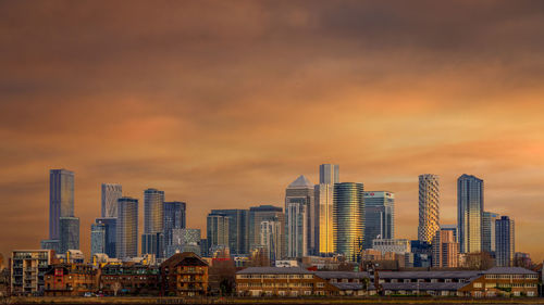 Modern buildings against sky during sunset