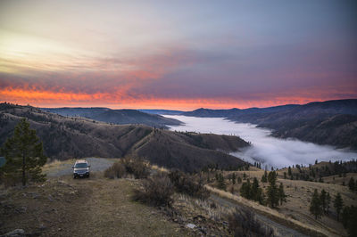 Pink sunrise in the mountains with clouds in the valley