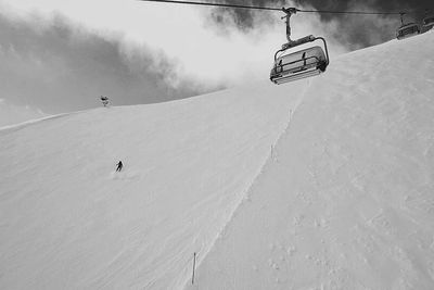 Low angle view of ski lift over snow covered mountain