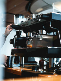 Coffee shop modern black espresso machine service with cristal cup filled with coffee.