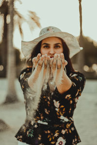 Portrait of beautiful young woman standing against blurred background