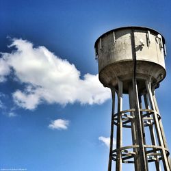 Low angle view of water tower against blue sky