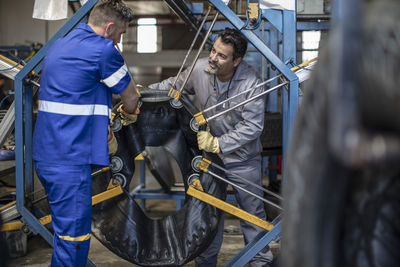 Two tire repairmen working together in factory