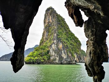 Scenic view of rock formation by sea against sky