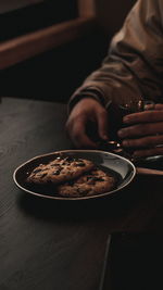 Midsection of man holding food on table