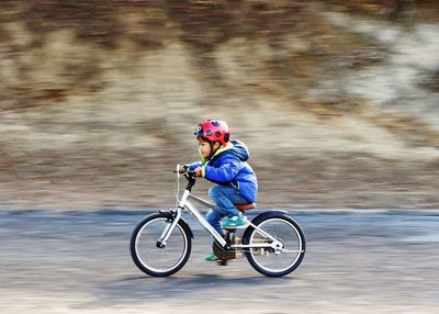 Boy riding bicycle on road