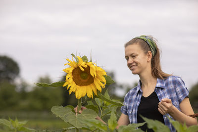 Young woman working as vegetable grower or farmer in the field