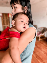 Portrait of mother and baby sitting at home