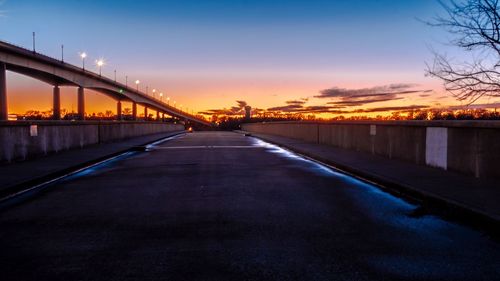 Road passing through illuminated city at night