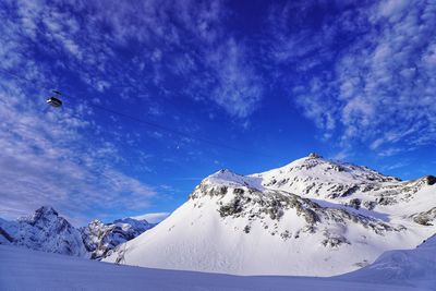 Snow covered mountain against blue sky