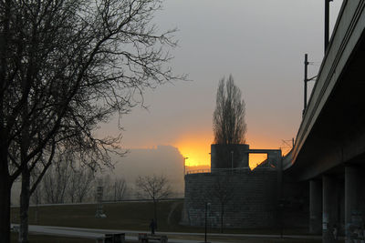 Silhouette of bridge and trees against sky during sunset