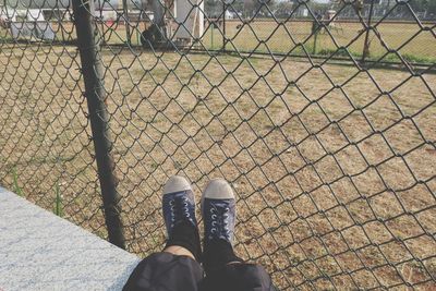 Low section of man standing by fence