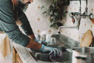 Side view of man washing hands