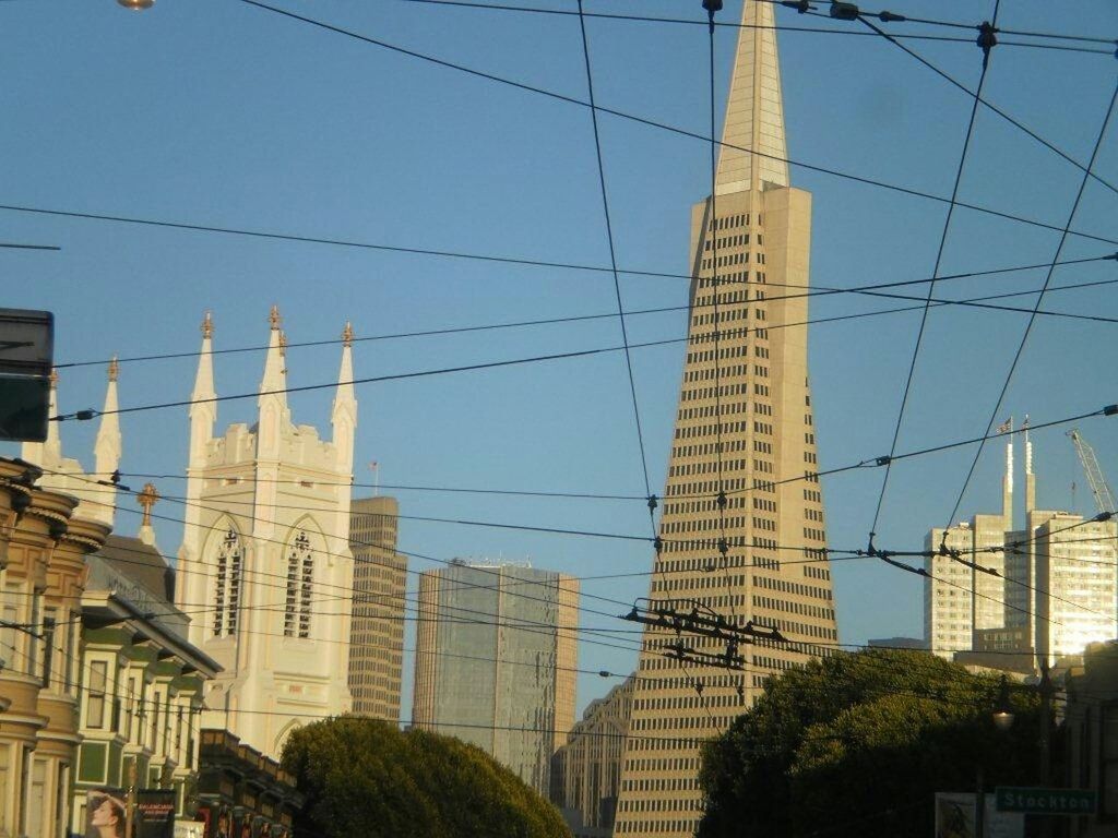 architecture, building exterior, built structure, low angle view, city, building, modern, clear sky, office building, skyscraper, tall - high, blue, sky, tower, day, residential building, outdoors, cable, sunlight, power line