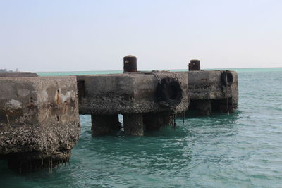 Old ruins on sea against clear sky