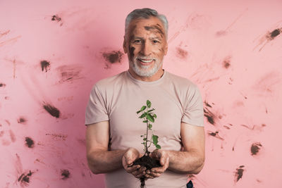 Portrait of smiling man standing against wall