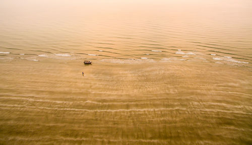 Aerial view of boat in sea during sunset