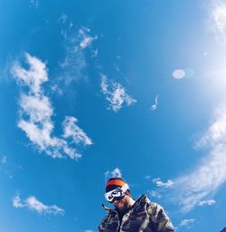 Low angle view of man against blue sky