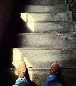 Low section of man standing on tiled floor