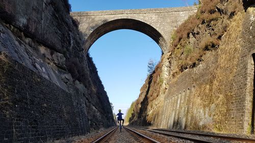 Rear view of woman on wall against clear sky