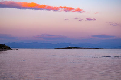 Scenic view of sea against dramatic sky during sunset