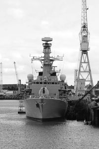 Ship moored at harbor against sky