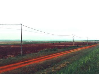 Country road along landscape and against clear sky