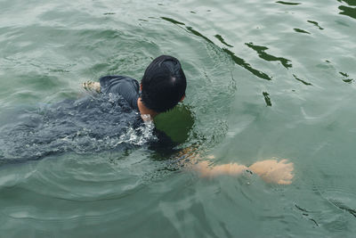 Rear view of man swimming in sea