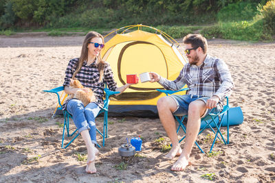 Friends sitting on tent