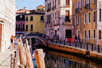 People by canal in city