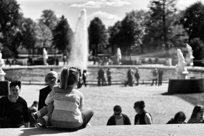 Rear view of girl sitting in park