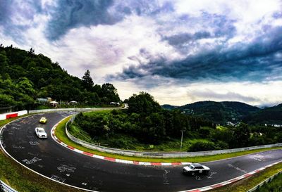 Road passing through landscape against cloudy sky