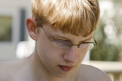 Close-up of shirtless boy wearing eyeglasses