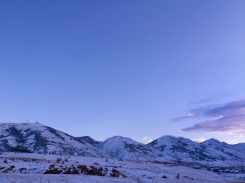 Scenic view of snowcapped mountains against clear blue sky