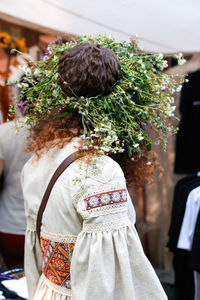 Rear view of woman standing by christmas tree
