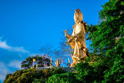 Low angle view of statue against blue sky